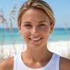 Sterling silver aqua Swarovski crystal whale tail drop earrings worn on both ears on model at Florida beach — Crabby Mermaid