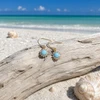 Gold plated Larimar and cubic zirconia drop earrings on driftwood at Florida Gulf Coast beach - Crabby Mermaid