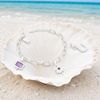 Interchangeable charm bracelet in sterling silver with amethyst charms in seashell on Florida Gulf Coast beach — Crabby Mermaid
