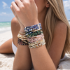 Stone wrap bracelets stacked on a model's wrist at a Florida Gulf Coast beach showing mix and match styling - Crabby Mermaid