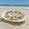 Stone Wrap Amazonite Gold coiled in a seashell on a white sand Florida Gulf Coast beach — Crabby Mermaid