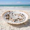 Stone Wrap Mexican Onyx coiled in a seashell on a white sand Florida Gulf Coast beach — Crabby Mermaid