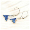 Sterling silver whale tail earrings with sapphire blue crystals displayed on soft fabric ‚Äî lever-back closure ‚Äî Ocean Jewelry Collection