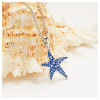 Sterling silver sapphire blue starfish necklace with crystal accents displayed on seashell - handcrafted in Ireland - Crabby Mermaid