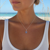 Sterling silver sapphire blue starfish necklace with crystal accents worn by sandy blonde model on Florida beach — handcrafted in Ireland — Crabby Mermaid