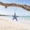 Sterling silver sapphire blue starfish necklace with crystal accents hanging from driftwood on Florida beach - handcrafted in Ireland - Crabby Mermaid