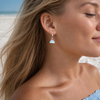 Model wearing opalite half-moon interchangeable charm earring on silver hoop at Florida Gulf Coast beach — Crabby Mermaid