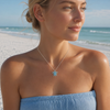 Model wearing sterling silver aquamarine crystal sea turtle necklace with Swarovski crystal halo on Florida Gulf Coast beach — Crabby Mermaid