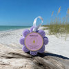 Spongellé French Lavender Wild Flower buffer on driftwood at Florida Gulf Coast beach with sea oats and turquoise water - Crabby Mermaid