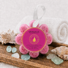 Spongellé Bulgarian Rose Wild Flower Body Wash Buffer on a wooden spa tray with a rolled white towel, seashells, and sea glass