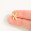 Gold starfish charm necklace size reference shown on fingertip - 15mm x 18mm charm