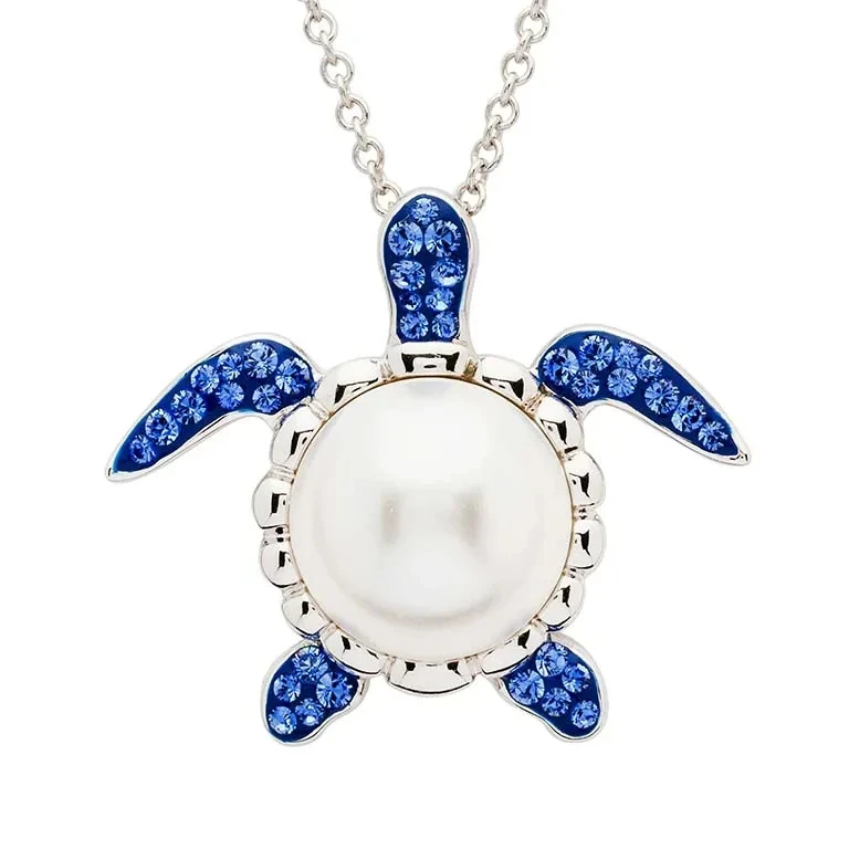 Sterling silver sea turtle pendant with freshwater pearl body and sapphire crystal flippers on white background - handcrafted in Ireland - Crabby Mermaid
