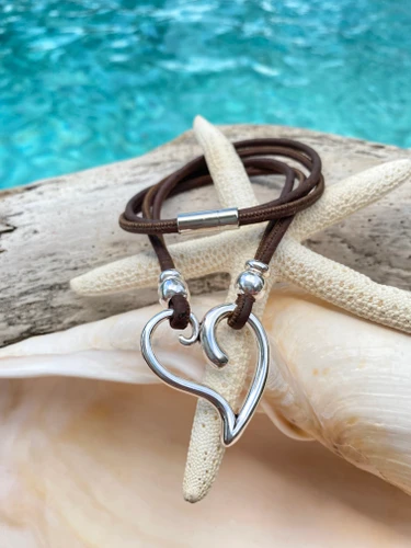 Sterling silver heart cork necklace with brown cork cord and magnetic clasp displayed on starfish and seashell — Florida artisan jewelry