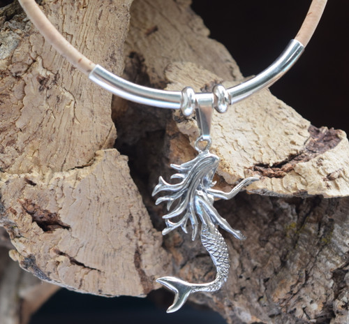 Close up of detailed sterling silver dancing mermaid pendant with flowing hair and scaled tail — Florida artisan jewelry