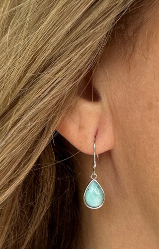 Larimar Teardrop Earrings set in Sterling Silver

Celebrate your femininity with brilliant color and simple charm with these “go-to” earrings. Our Larimar teardrop dangle earrings feature highly polished, teardrop-shaped oval Larimar wrapped in lustrous sterling silver with French hook wire for a simple finish. These brilliant pair of earrings are the perfect everyday set. Dress them up or wear them casually; either way, you will love them. They also make an ideal gift for a beach or ocean lover; the beautiful shades of blue Larimar stones give them a picture-perfect coastal vibe. Reminiscent of the tropical blue waters of the Dominican Republic, these glowing teardrop earrings make an enchanting statement. Set in sterling silver, these exotic drop earrings are the perfect year-round touch of summer. Pair these earrings with our matching Larimar Teardrop Necklace to complete your beach vibe look.

About the Larimar Teardrop Set in Sterling Silver Earrings:

Sterling Silver with French Hook Wire

Larimar Charm is 1/2"

Pair them with one of our Larimar Teardrop Necklaces to complete your perfect look.