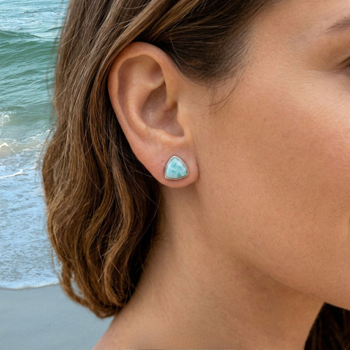 Larimar trillion stud earring worn on model at beach — genuine Dominican Republic Larimar in .925 sterling silver bezel setting — Crabby Mermaid