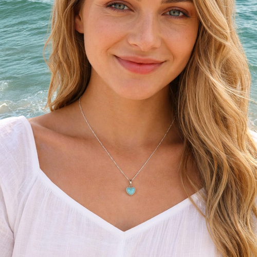 Larimar heart necklace in sterling silver worn on sandy blonde model at Florida Gulf Coast beach — genuine Dominican Republic Larimar — Crabby Mermaid
