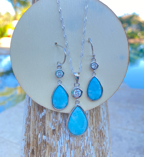 Genuine Larimar teardrop pendant and matching earring set with cubic zirconia accents displayed on wood — coastal jewelry