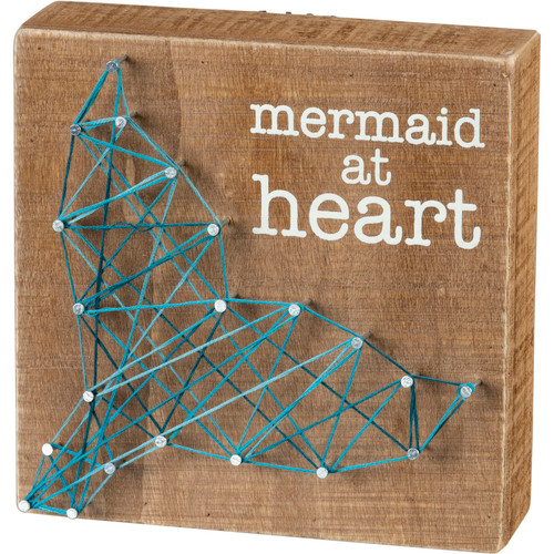 A wooden block featuring a hand-strung mermaid tail design and "Mermaid At Heart" sentiment. Easy to hang by back sawtooth or can free-stand alone.