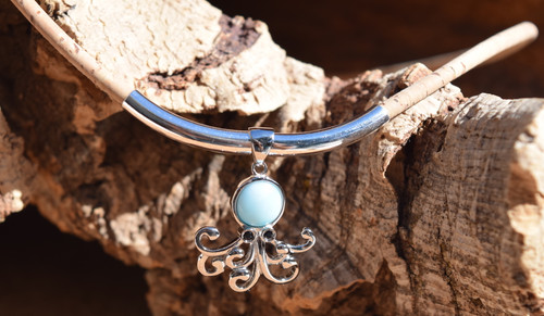 Close-up of genuine Larimar octopus pendant with open-work filigree tentacles hanging from large sterling silver tube on cork cord ‚Äî Florida artisan jewelry