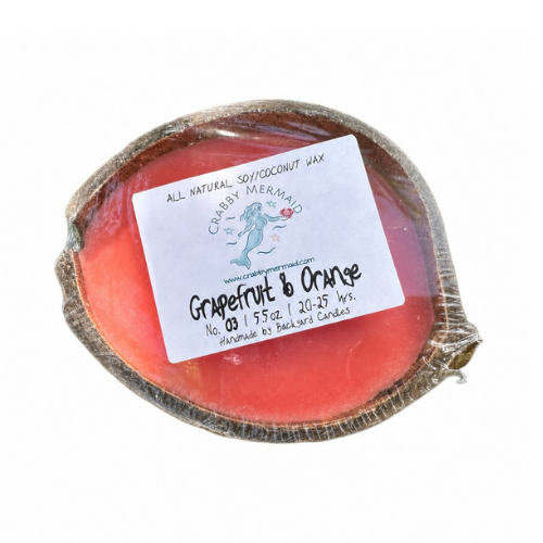 Grapefruit and orange half shell coconut candle with Crabby Mermaid label on tropical leaf background — all natural soy coconut wax — 5.5 oz
