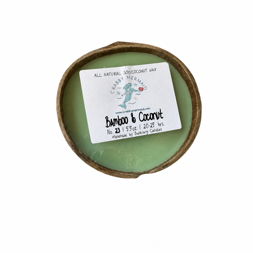 Bamboo and coconut coconut shell candle on beach table between two lounge chairs with tropical drinks — coastal candle gift — Crabby Mermaid