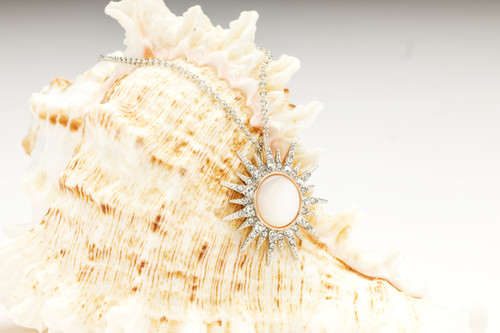 Sterling Silver Mother Of Pearl / Crystal Rose Gold Sun Necklace

Our Sun Necklace is a stunning and glamorous accessory that combines the symbology of the Sun and the Mother of Pearl in one piece. The Sun represents many of the best memories that occur in the light of the Sun. Similarly, it symbolizes vigor, optimism, clarity, and self-assurance. The Mother of Pearl, on the other hand, signifies transformation and growth. Hence, this stunning piece of jewelry is the perfect gift for someone who is the beacon of light in your life.

This stunning Sterling Silver Mother of Pearl and Crystal Rose Gold Sun Necklace houses 33 sparkling crystals. A plain bail links the pendant to an 18" Sterling Silver chain with a 2" adjustable extension. This feature lets you choose the length to suit your neckline.