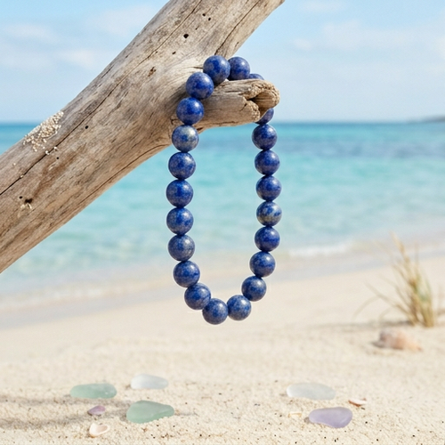 Lapis Lazuli 8mm gemstone beaded stretch bracelet hanging on driftwood on Florida Gulf Coast beach with sea glass — Crabby Mermaid