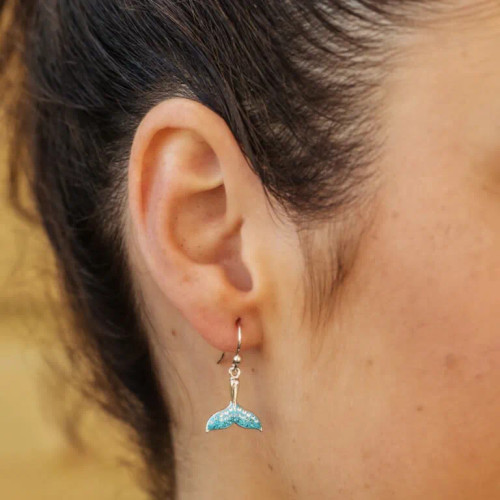 Explore elegance and symbolism with our Blue Whale Tail Drop Earrings from Crabby Mermaid. Crafted in Sterling silver, adorned with sparkling crystals, and featuring a turquoise blue whale tail design, these earrings symbolize speed, strength, and joy. The serene blue and clear crystals add a touch of tranquility. Perfect for any occasion, pair them with our matching pendant for a complete set. Elevate your style with these timeless accessories from Crabby Mermaid, seamlessly blending sophistication and meaning.