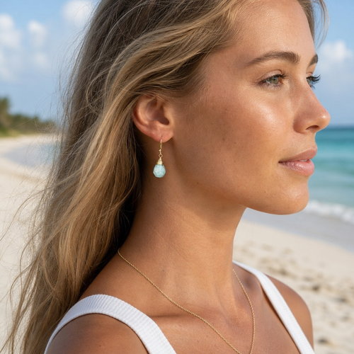 Gold-plated amazonite jasper teardrop earrings worn on model side profile at Florida beach — Crabby Mermaid