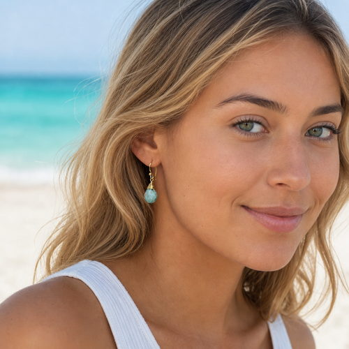 Gold-plated amazonite jasper teardrop earrings worn on model at Florida beach — wire-wrapped gold setting — Crabby Mermaid