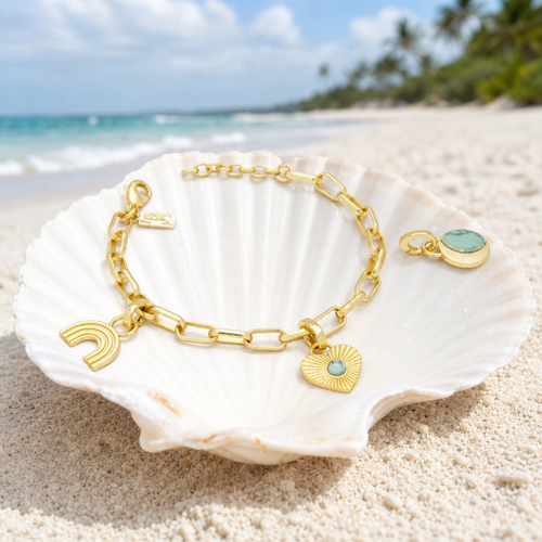 Interchangeable charm bracelet in 14K gold with blue howlite charms in seashell on Florida Gulf Coast beach — Crabby Mermaid