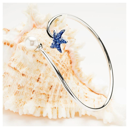Discover the Sterling Silver Pearl with Sapphire Crystal Starfish Bangle, a symbol of hope, healing, and happiness. Featuring a crystal-studded starfish and a freshwater pearl, this adjustable cuff bangle adds coastal charm to any look. Shop now at crabbymermaid.com to find your perfect coastal-inspired jewelry piece!