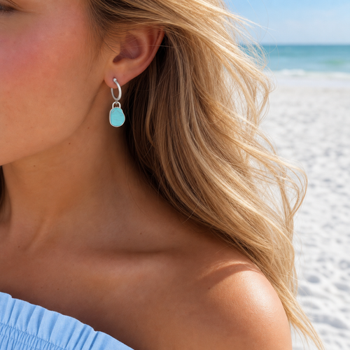Model wearing turquoise organic stone drop charm on silver hoop earring at Florida Gulf Coast beach — Crabby Mermaid