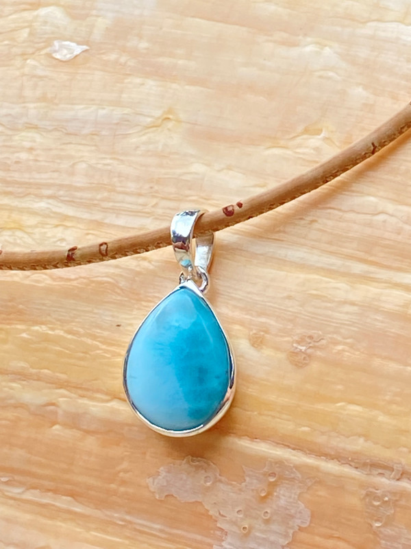 Genuine Larimar teardrop pendant on natural Portuguese cork cord displayed on driftwood — Crabby Mermaid