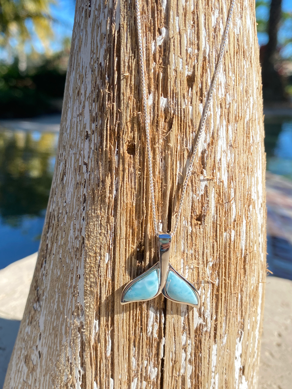 Larimar whale tail necklace displayed on palm tree in Florida sunshine — hand assembled by Crabby Mermaid