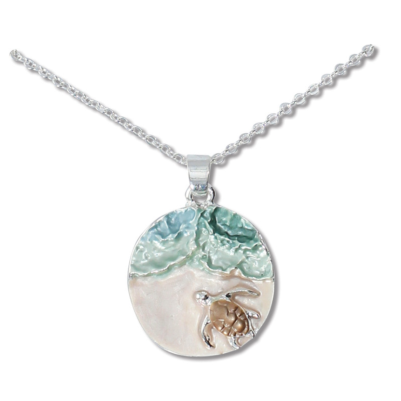 Silver-toned sea turtle disc pendant necklace with aqua enamel wave and baby turtle detail on white background — coastal jewelry — Crabby Mermaid
