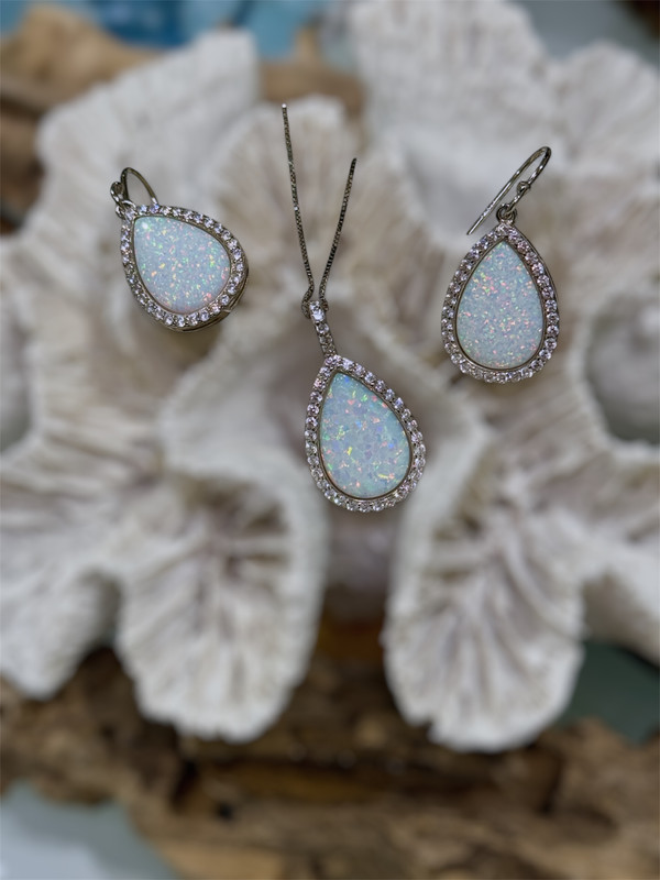 White opal and cubic zirconia teardrop necklace and earring set displayed on white coral — hand assembled by Crabby Mermaid