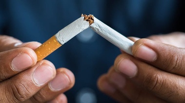 Pair of hands breaking a cigarette in half