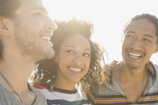 Three smiling individuals pose together, embodying support for those quitting smoking.