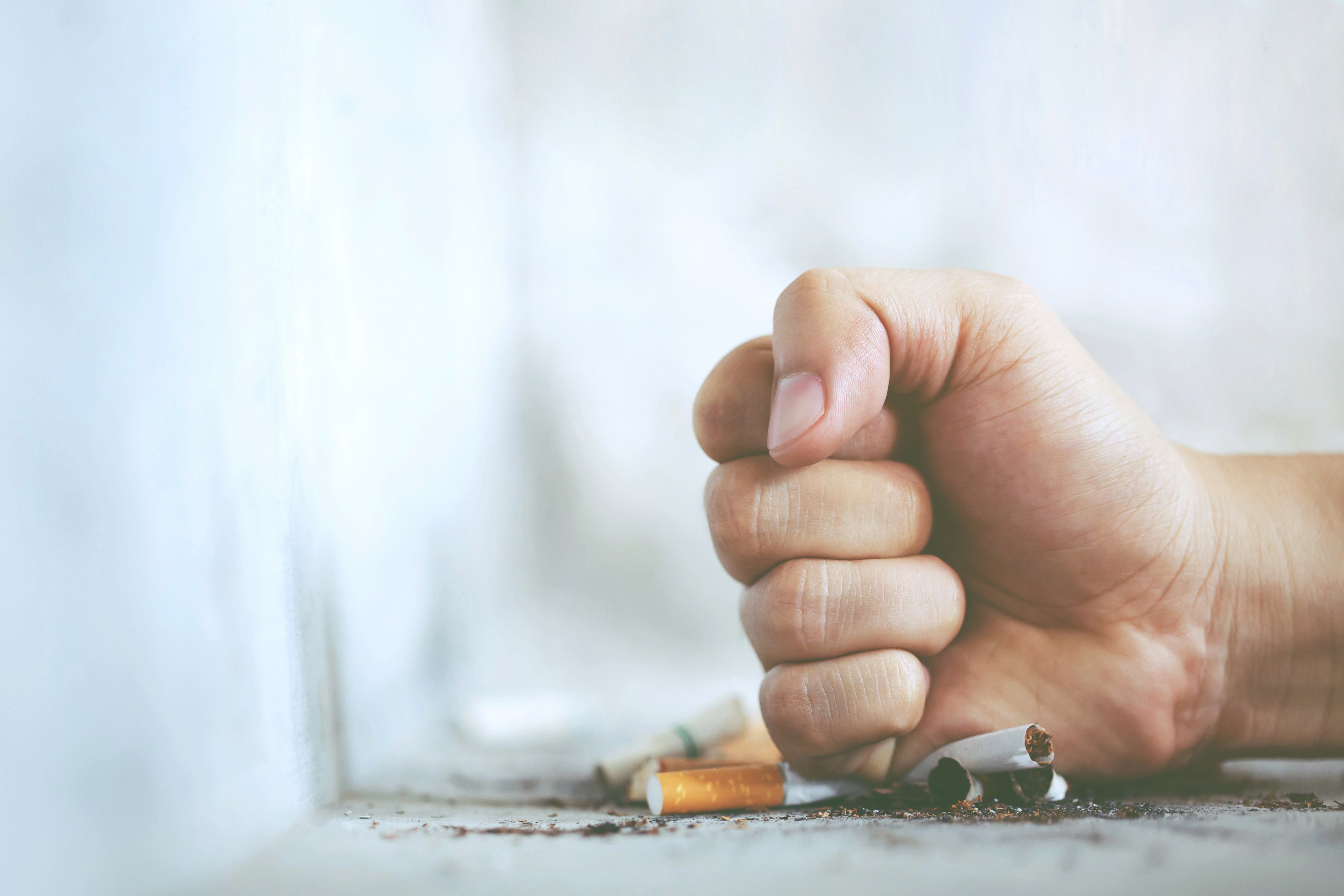 Man’s fist smashing a cigarette