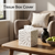 Stylish white tissue box cover placed on a wooden table in a cozy living room setting
