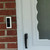Doorbell cover plate installed next to front door, clean entryway with hidden wiring