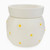 A white ceramic wax warmer with a rounded body featuring embossed white daisy flowers with yellow centers and a matching removable top dish