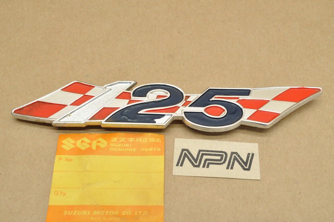 NOS Suzuki TC125 TS125 Oil Tank Side Cover Emblem Badge 68141-28000