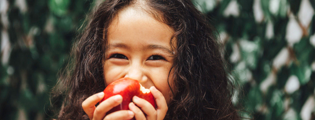 A little girl eating an apple