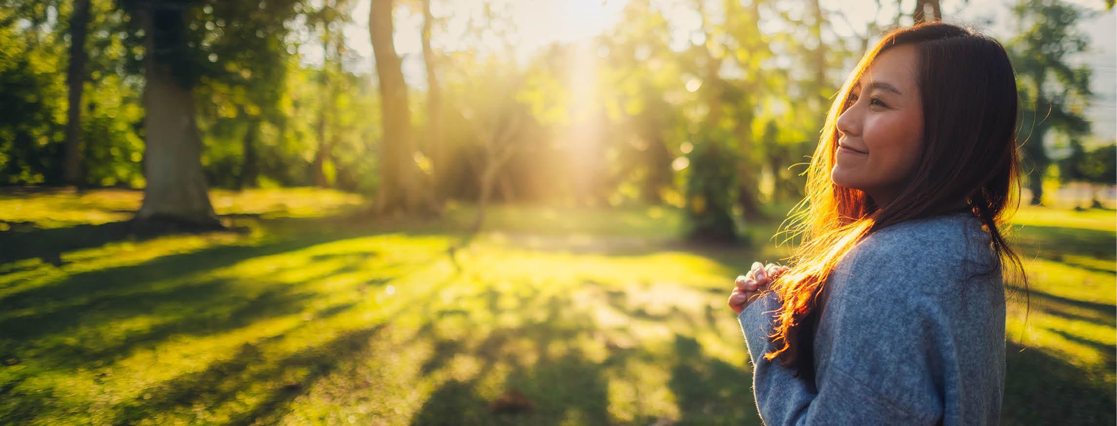 Smiling woman enjoying a peaceful sunny morning outdoors