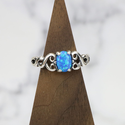 A sterling silver ring featuring an intricate Celtic heart knot design with a luminous blue opal gemstone accent. Symbolizing eternal love and unity, this elegant piece is a meaningful Celtic jewelry treasure.