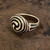 A handcrafted Celtic Triskele ring available in bronze. The triple spiral design represents eternity, cycles of life, and spiritual growth. Each artisan-made piece is unique, combining timeless Celtic heritage with modern craftsmanship.