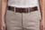 Brown Celtic knot leather belt worn with beige slacks on a female model
